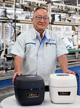 　象印マホービンの市川典男社長と高級炊飯器「炎舞炊き」＝２４日、大阪府大東市