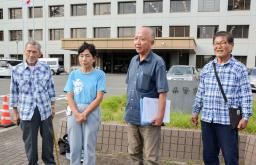 　佐賀県警本部前で取材に応じる日本国民救援会佐賀県本部の山口勝弘事務局長（右から２人目）＝２４日午後