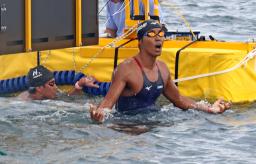 　オープンウオーター日本選手権の男子１０キロを制した南出大伸。左は２位の辻森魁人＝千葉県館山市北条海岸沖