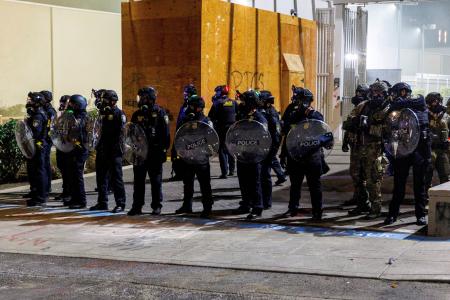 　トランプ大統領の移民政策に抗議するデモの警備に当たるＩＣＥ施設の職員＝９月１日、ポートランド（ロイター＝共同）