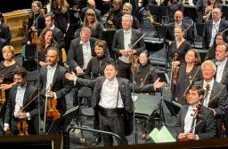 　２７日、ブザンソン国際若手指揮者コンクールの決勝で、大きな拍手を受ける米田覚士さん（下中央）＝フランス東部ブザンソン（共同）