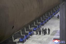 　潜水艦の船底部分を視察する北朝鮮の金正恩朝鮮労働党総書記（手前左から２人目）（朝鮮中央通信＝共同）