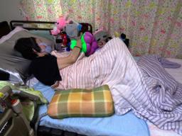 　自宅の介護ベッドでほぼ寝たきりの生活を送る女性＝１０日、大阪市