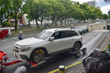 　冠水した地下駐車場から、レッカー車で運び出された浸水被害に遭った車両＝２９日午前、三重県四日市市