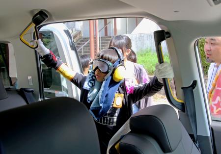 　トヨタ自動車が開いた高齢者を疑似体験するイベントで、タクシーに乗り込む児童＝２日午前、愛知県豊田市