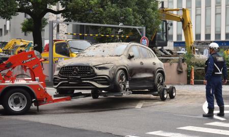 　冠水した地下駐車場から運び出された、浸水被害に遭った車両＝３日午前１１時４分、三重県四日市市