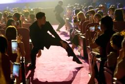 　ダンスする男性舞踏団「公狗劇場」のメンバーにスマホを向ける女性客＝７月、中国上海市（共同）