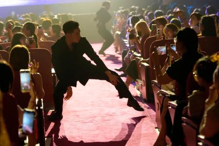 　ダンスする男性舞踏団「公狗劇場」のメンバーにスマホを向ける女性客＝７月、中国上海市（共同）