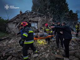 　ロシアの無人機とミサイルによる攻撃で破壊された住宅のがれきの上で、負傷者を搬送する救助隊員ら＝５日、ウクライナ西部リビウ州（ウクライナ非常事態庁提供・ロイター＝共同）