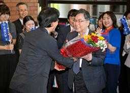 　ノーベル生理学・医学賞の受賞決定から一夜明け、大阪大の熊ノ郷淳学長（左）から花束を受け取る坂口志文特任教授＝７日朝、大阪府吹田市