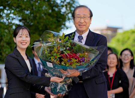　ノーベル化学賞の受賞決定から一夜明け、職員から花束を受け取る京都大の北川進氏（右）＝９日午前、京都市左京区