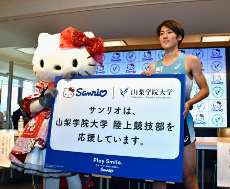　ハローキティと登場した山梨学院大陸上競技部の平八重充希副主将＝９日午後、甲府市