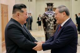 　訪朝した中国の李強首相（右）と握手する北朝鮮の金正恩朝鮮労働党総書記＝９日（朝鮮中央通信＝共同）
