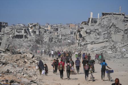 　破壊された建物の間を歩く人たち。イスラエルとイスラム組織ハマスの停戦が発効した＝１０日、ガザ北部ガザ市（ＡＰ＝共同）