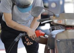 　東京都内のガソリンスタンドで給油する人