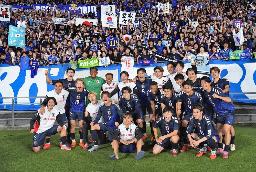 　ブラジルから初勝利を挙げ、サポーターと写真に納まる日本代表＝１４日、味の素スタジアム