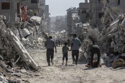 　　１６日、イスラエル軍の攻撃で荒廃したガザ北部ガザ市で、家に戻るパレスチナ人（ゲッティ＝共同）