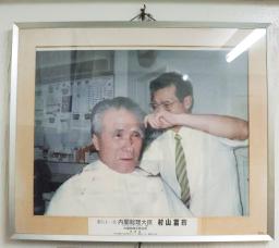 　村山富市元首相が通っていた理容室に飾られている写真＝１７日午後、大分市