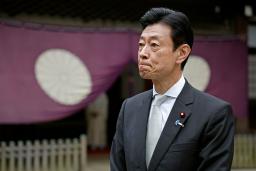 　靖国神社を参拝し、記者団の取材に応じる西村元経産相＝１８日午前、東京・九段北