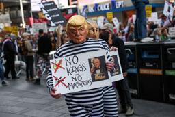 　トランプ大統領の政治手法に抗議するデモで「ＮＯ　ＫＩＮＧＳ（王はいらない）」を掲げる参加者＝１８日、ニューヨーク（ロイター＝共同）