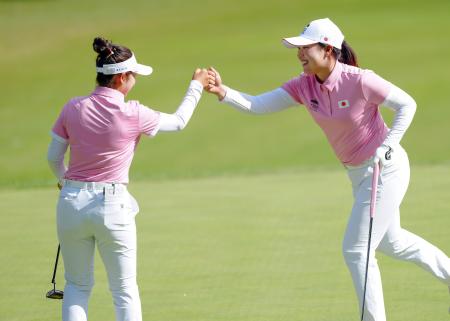 第2ラウンド、11番でバーディーを奪い、タッチを交わす山下美夢有(左)と竹田麗央=新朝鮮CC(共同)
