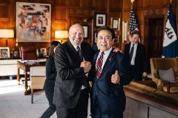 　９月、ラトニック米商務長官（左）がＸ（旧ツイッター）に投稿した赤沢氏と手を取り合う写真