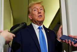 　大統領専用機内で記者団の取材に応えるトランプ大統領＝２５日（ロイター＝共同）