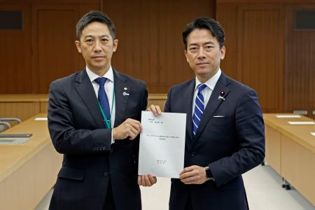 秋田県の鈴木健太知事(左)から要望書を手渡された小泉防衛相=28日午前、防衛省