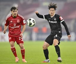 　デュッセルドルフ戦で競り合うフライブルクの鈴木唯（右）＝デュッセルドルフ（共同）