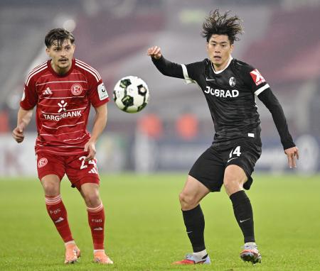 　デュッセルドルフ戦で競り合うフライブルクの鈴木唯（右）＝デュッセルドルフ（共同）