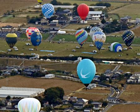 佐賀インターナショナルバルーンフェスタが開幕し、浮かび上がる熱気球=30日午前、佐賀市(共同通信社ヘリから)