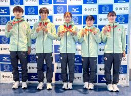 　トランポリンの世界選手権から帰国し、メダルを手に撮影に応じる宮野隼人（左から２人目）、田中沙季（同４人目）ら＝１１日、羽田空港