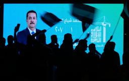 　イラクのスダニ首相が映ったスクリーン前で、選挙結果を喜ぶ支持者＝１２日、バグダッド（ＡＰ＝共同）