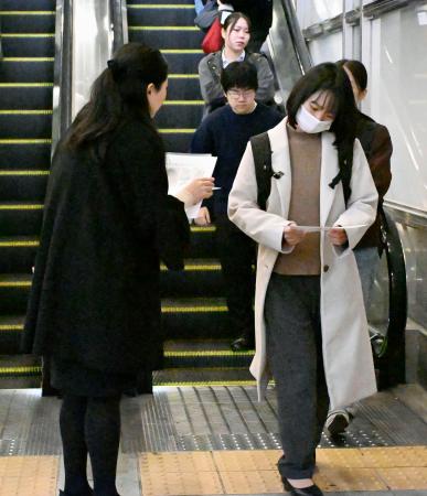 　梶谷恭暉さんの情報提供を求め、ビラを配る母親（左）＝１３日午前、ＪＲ岡山駅前