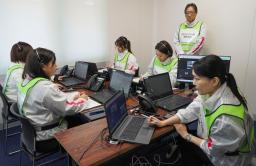 　大規模災害時の安否不明者に関する電話対応訓練で、手順を確認する民間企業のスタッフ＝１４日午前１０時１１分、徳島県美馬市
