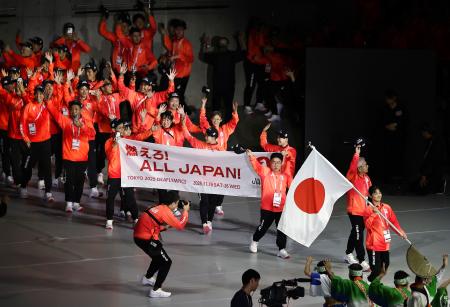 　「東京デフリンピック」の開会式で入場行進する日本選手団。旗手は空手女子の小倉涼＝１５日、東京体育館