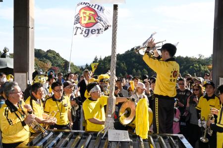 　信貴山朝護孫子寺の本堂で、プロ野球阪神タイガースの応援歌を響かせるファンら＝１６日午後、奈良県平群町