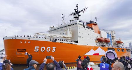 　海上自衛隊横須賀基地から出港する南極観測船「しらせ」と見送る家族や関係者＝１９日午前