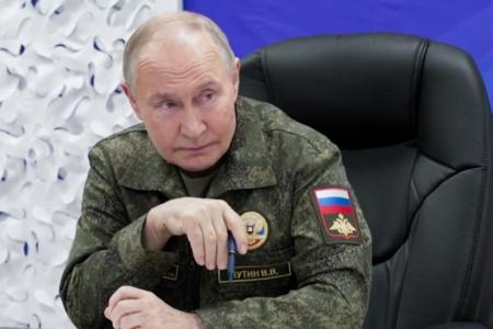 　２０日、ロシア国防省幹部から戦況の報告を受けるプーチン大統領（大統領府提供・タス＝共同）