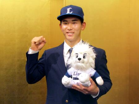 　西武への入団が決まり、ポーズをとる明大の小島大河捕手＝２１日、東京都内