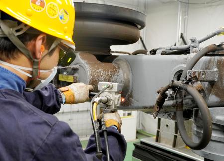 　レーザーを使い鉄道台車の塗膜を除去する作業＝２１日午後、名古屋市