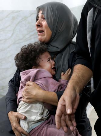 　イスラエル軍の攻撃を受けた後、医療処置を受けたパレスチナ人の母子＝２２日、ガザ（ロイター＝共同）