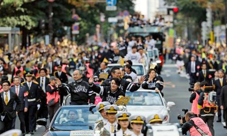 　プロ野球で５年ぶりの日本一に輝いたソフトバンクの優勝祝賀パレードで、声援に応える周東選手会長（手前右）ら＝２４日午前、福岡市