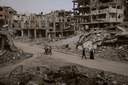 　破壊された街を歩くパレスチナの人々＝２４日、ガザ北部ガザ市（ＡＰ＝共同）