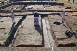 　藤原宮跡の調査区画で「大極殿院」の西門の幅を示す研究員ら＝２７日午前、奈良県橿原市