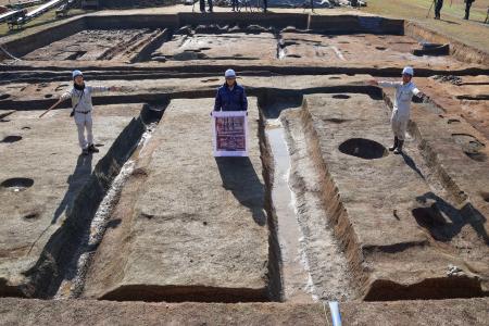 　藤原宮跡の調査区画で「大極殿院」の西門の幅を示す研究員ら＝２７日午前、奈良県橿原市