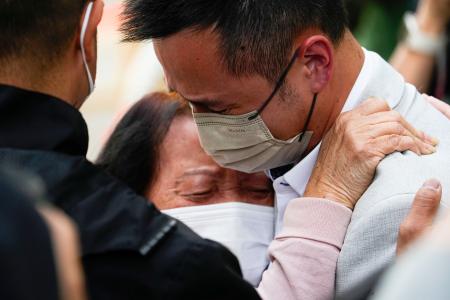 　安否不明者の確認所から出た直後、泣き崩れる人＝２７日、香港（共同）