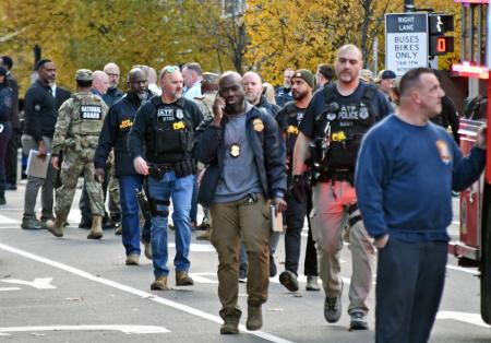 　米ワシントンの銃撃事件現場付近で対応に当たる捜査関係者ら＝２６日（共同）