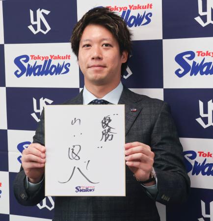 　契約更改交渉を終え、記者会見で来季の抱負を記した色紙を掲げるヤクルト・山田＝２８日、神宮球場