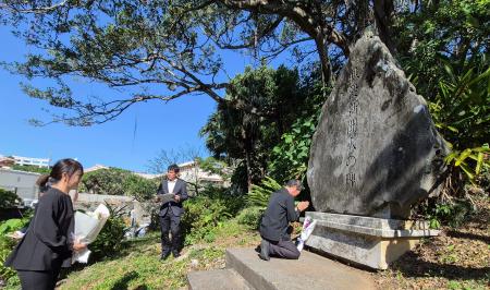 　「戦没新聞人の碑」に献花し、手を合わせる報道関係者＝３０日午前、那覇市